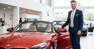 Friendly salesperson at a local car dealership in the UK next to a BMW Z4 Roadster, encouraging test drives of 2026 convertible cars.